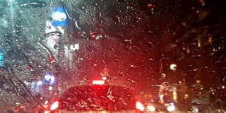 车外下雨，雨水滴落在车前与交通堵塞