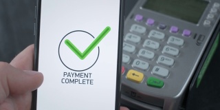 使用非接触式POS支付终端进行电话支付。用户在商店或餐厅使用智能手机购物。无现金钱包中的电子货币