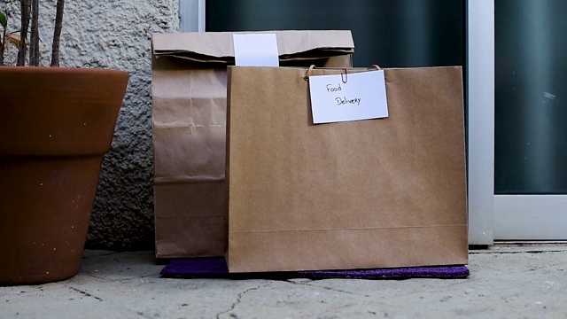 食物包放在家门口等着取。社会距离的概念。