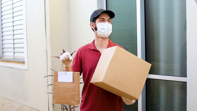 戴口罩和防护手套的送货员在住宅前。食品配送、杂货和用品的概念