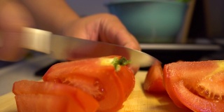 在切菜板上切鲜红的番茄