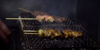 小吃摊上的烤鸡肉串的慢镜头。串东京