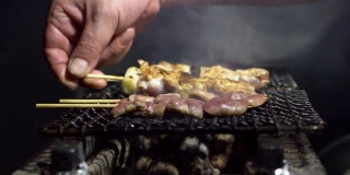 东京居酒屋日式酒吧厨师烹饪的慢镜头。日本的食物