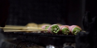 小吃摊上的烤鸡肉串的慢镜头。串秋葵
