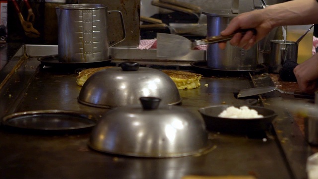 慢动作煎锅贴。厨师在铁锅上煎饺子