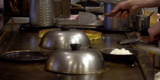 慢动作煎锅贴。厨师在铁锅上煎饺子