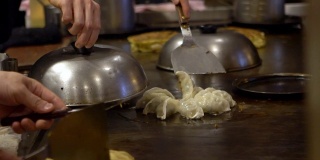煎guotie。专业厨师在铁锅上煎饺子