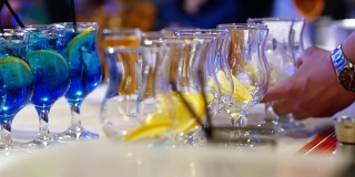 专业的调酒师将冰块和橙子放入玻璃杯中，并配以鸡尾酒
