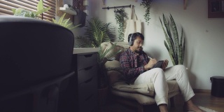 潮男在家用平板电脑和手写笔听音乐和画画
