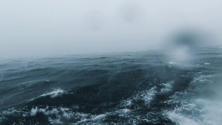 在极端天气季风风暴期间，颠簸的船穿越海洋海景视频素材模板下载