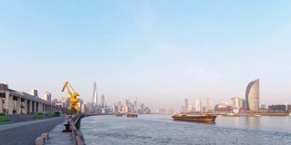 时间流逝镜头的货船舰队航行在黄浦江与上海天际线城市景观背景在阳光明媚的一天，4k视频b卷拍摄。