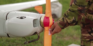 人从商用空中侦察或军用飞机的螺旋桨上取下盖子。军用工程师为军用飞行作业准备无人驾驶飞行器。