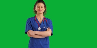 可爱的女医生看着镜头上的色度键绿色屏幕背景，情绪积极