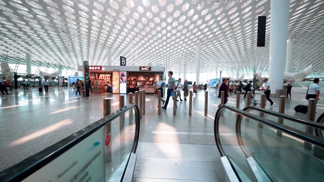 乘客在机场步行，在深圳火车站自动扶梯