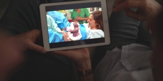爷爷奶奶在打视频电话，看着他们的孙子在医院出生