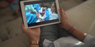奶奶在打视频电话，看着她的孙子在医院刚出生
