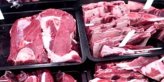 新鲜的牛肉在市场柜台，肉店。展示新鲜切开的牛肉或猪肉。