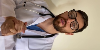 中年男子医生做一个视频通话- POV的手机