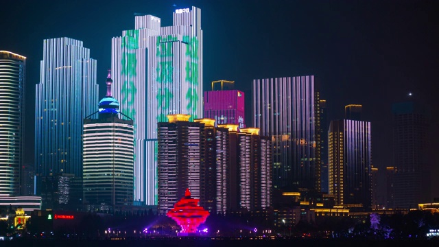 夜间照明展示青岛市中心纪念碑湾全景，时间流逝4k中国