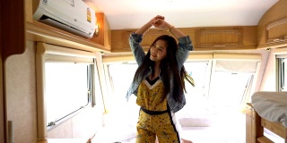 年轻的亚洲女人在露营车里跳舞
