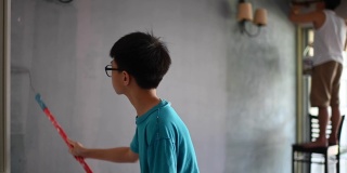 亚裔华人家庭成员帮父亲粉刷房子