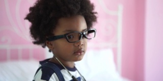 非裔美国小男孩试图戴眼镜和医用听诊器