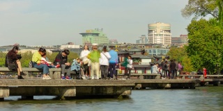 阳光明媚的一天，杭州城著名的湖泊，游客拥挤的码头湾，时光流逝的全景4k中国