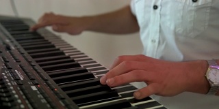 音乐家的手指放在电子合成器的键盘上