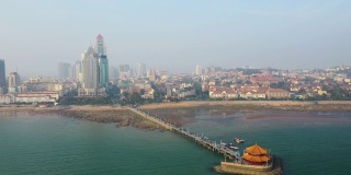 阳光明媚的夜晚青岛城著名的海滩湾宝塔拥挤的码头航拍全景4k中国