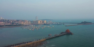 阳光明媚的夜晚青岛著名的海滩湾码头宝塔拥挤的码头航拍全景4k中国