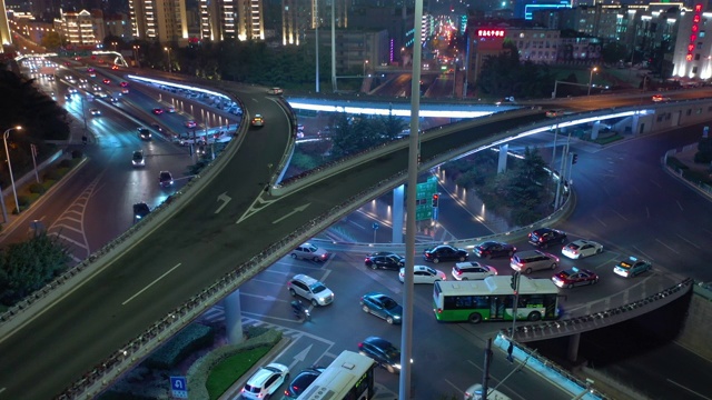 青岛市夜间灯火通明，繁忙交通路口架空俯仰全景4k中国