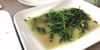 用筷子夹起绿色蔬菜，中国食物用油