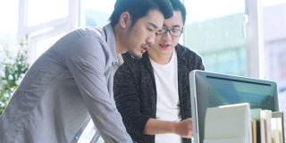 两个亚洲商人使用电脑在办公室工作