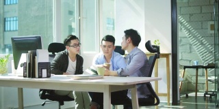 三位亚洲企业家在办公室讨论生意