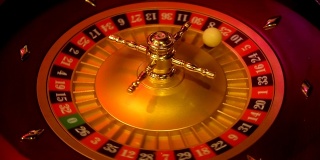 赌场轮盘赌在运动与旋转轮和球。获胜号码23和颜色红色是由轮盘赌轮决定的。低光下的轮盘赌桌布局