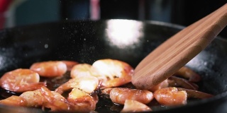 用竹铲将虾放入锅中，用慢动作搅拌。