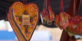 在节日帐篷下面悬挂着心形和姜饼形状的Licitars。街头出售的袋装糖果。