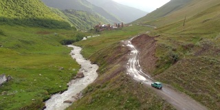 在格鲁吉亚郁郁葱葱的高加索山区，一辆旧汽车行驶在一条崎岖不平的土路上。
