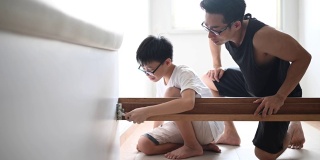 一个亚裔华人家庭搬家父子组装床架