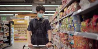 一名亚洲男子在超市购物时戴上口罩