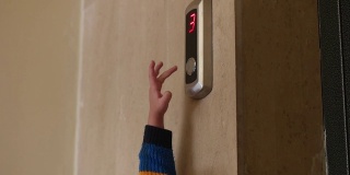 小孩的手指按电梯的下按钮