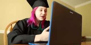 青少年毕业生在帽子和长袍视频聊天