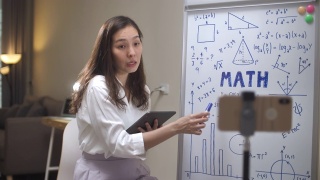 亚洲女教师在家里用她的智能手机在线教学视频素材模板下载