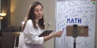 亚洲女教师在家里用她的智能手机在线教学