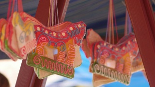 马形状的姜饼悬挂在节日帐篷下面。街头出售的袋装糖果。视频素材模板下载