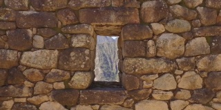 多莉在透过石头窗户看山。秘鲁库斯科的马丘比丘