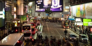 2019年1月8日，中国香港，一群人在夜间过马路。交通繁忙的人们，路上有汽车和电车。