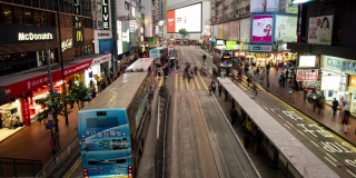 2019年1月8日，中国香港，一群人在夜间过马路。交通繁忙的人们，路上有汽车和电车。