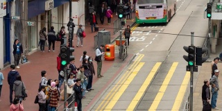 2019年1月8日，中国香港，4k时间间隔人群过马路。交通繁忙的人们，路上有汽车和电车。