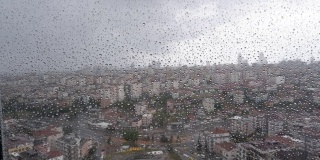 模糊了城市背景的春雨落在窗户玻璃上。